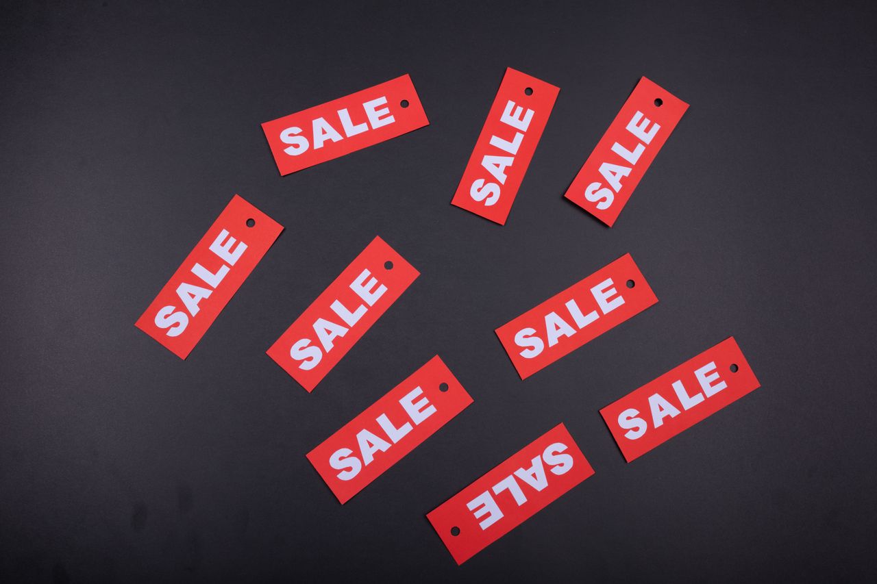 Red sale tags arranged on a dark background, ideal for retail promotions.